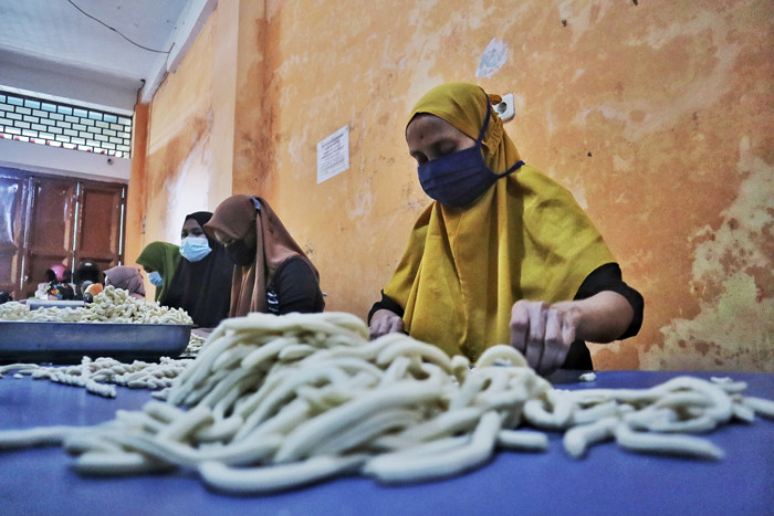 Sejumlah pekerja membuat Kue Otere (tali tali) di Makassar, Sulawesi Selatan, Rabu (21/4/2021).
