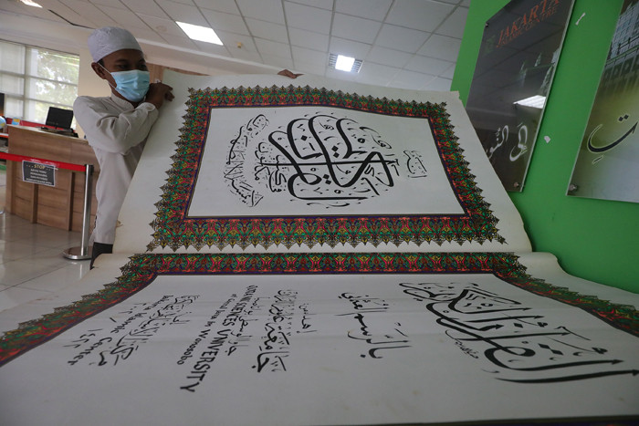 Petugas merawat Alquran raksasa di Perpustakaan Jakarta Islamic Centre (JIC), Jakarta Utara, Jumat (23/4/2021).