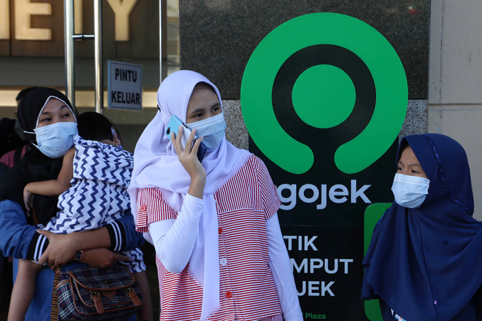 Pelanggan menunggu jemputan di titik jemput dan antar Gojek instan di Royal Plaza Surabaya, Jawa Timur, Kamis (22/4/2021).
