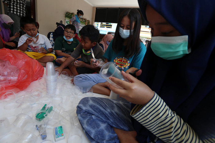 Sejumlah anak belajar membuat lampu gantung berbahan gelas air mineral bekas di Kampung Herbal, Surabaya, Jawa Timur, Sabtu (24/4/2021).