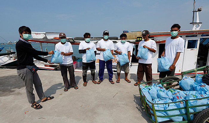 Sejumlah wartawan dari komunitas Jurnalis Peduli menyalurkan bantuan paket sembako kepada warga pesisir di Pulau Panjang, Banten, Sabtu (24/4/2021).