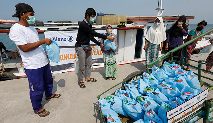 Sejumlah wartawan dari komunitas Jurnalis Peduli menyalurkan bantuan paket sembako kepada warga pesisir di Pulau Panjang, Banten, Sabtu (24/4/2021).