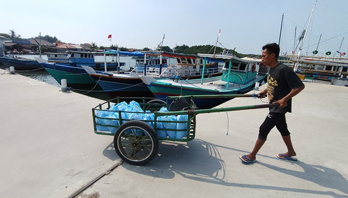 Sejumlah wartawan dari komunitas Jurnalis Peduli menyalurkan bantuan paket sembako kepada warga pesisir di Pulau Panjang, Banten, Sabtu (24/4/2021).