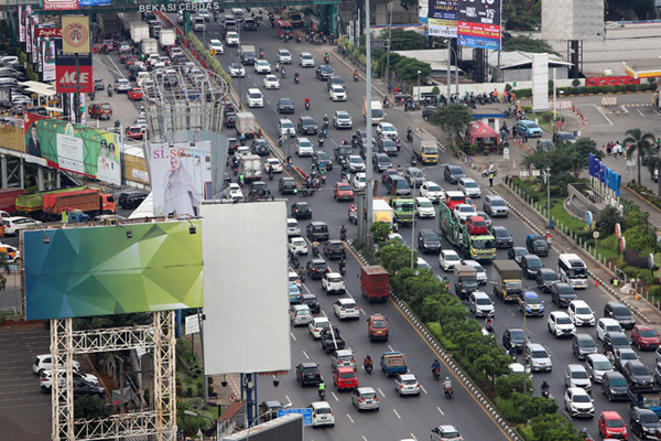 Pengendara mobil dan motor terjebak kemacetan di kawasan Bekasi Barat, Kota Bekasi, Jawa Barat, Minggu (25/4/2021).