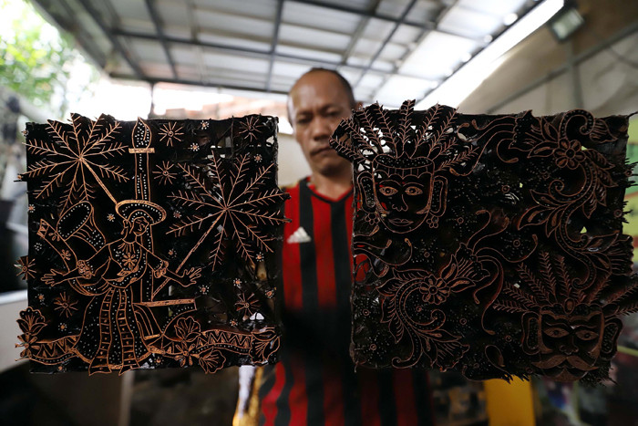 Pekerja menyelesaikan pewarnaan batik di lokasi pembuatan batik terogong khas betawi di Jakarta, Selasa (27/4/2021).