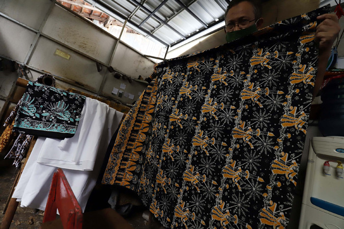 Pekerja menyelesaikan pewarnaan batik di lokasi pembuatan batik terogong khas betawi di Jakarta, Selasa (27/4/2021).