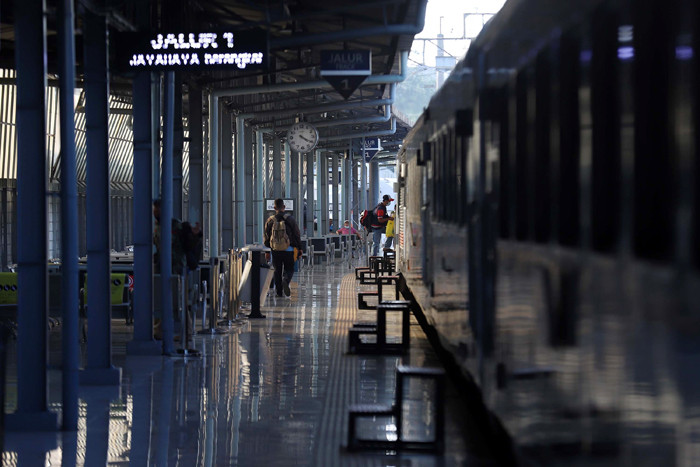 Calon penumpang berjalan di area keberangkatan Stasiun Pasar Senen, Jakarta, Senin (26/4/2021).
