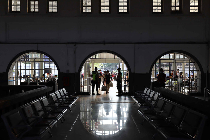 Calon penumpang berjalan di area keberangkatan Stasiun Pasar Senen, Jakarta, Senin (26/4/2021).