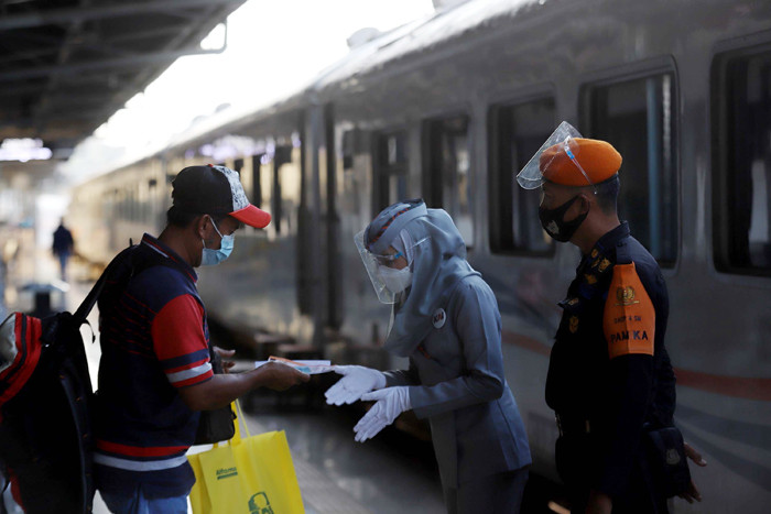 Calon penumpang berjalan di area keberangkatan Stasiun Pasar Senen, Jakarta, Senin (26/4/2021).