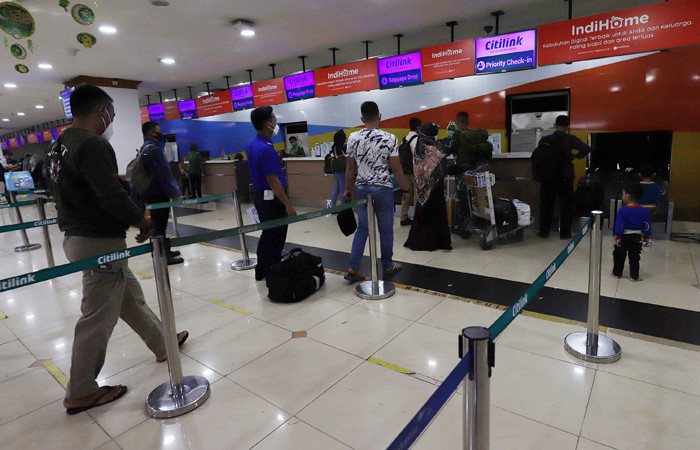 Calon penumpang mengantre pemeriksaan berkas test PCR dan tiket pesawat di pintu keberangkatan di Bandara Halim Perdanakusuma, Jakarta, Rabu (28/4/2021).