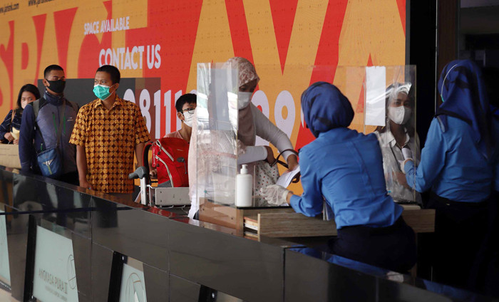 Calon penumpang mengantre pemeriksaan berkas test PCR dan tiket pesawat di pintu keberangkatan di Bandara Halim Perdanakusuma, Jakarta, Rabu (28/4/2021).