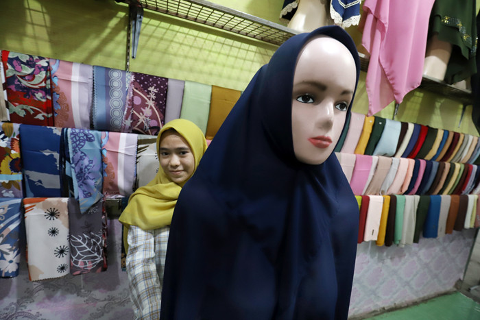 Penjual merapikan hijab di toko busana muslim di kawasan Pondok Melati, Kota Bekasi, Jawa Barat, Kamis (29/4/2021).