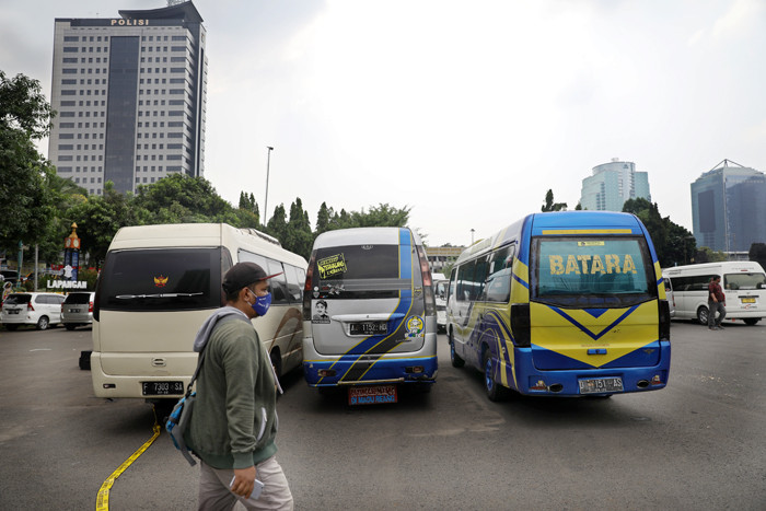Petugas kepolisian memeriksa barang bukti kendaraan travel gelap di Lapangan Presisi Dit Lantas PMJ, Jakarta, Kamis (29/4/2021).