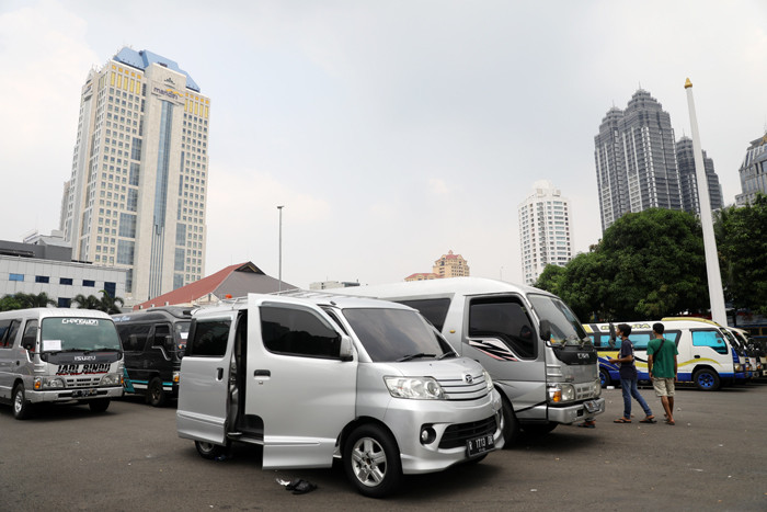 Petugas kepolisian memeriksa barang bukti kendaraan travel gelap di Lapangan Presisi Dit Lantas PMJ, Jakarta, Kamis (29/4/2021).