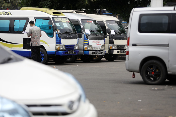 Petugas kepolisian memeriksa barang bukti kendaraan travel gelap di Lapangan Presisi Dit Lantas PMJ, Jakarta, Kamis (29/4/2021).