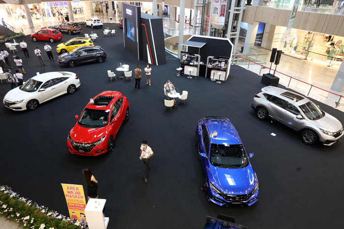 Sales Promotion Girl (SPG) berpose disisi unit mobil Honda saat pameran di Grand Atrium Pakuwon Mall Surabaya,  Jawa Timur, Jumat (30/4/2021).