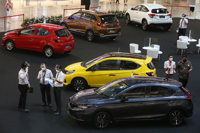 Sales Promotion Girl (SPG) berpose disisi unit mobil Honda saat pameran di Grand Atrium Pakuwon Mall Surabaya,  Jawa Timur, Jumat (30/4/2021).