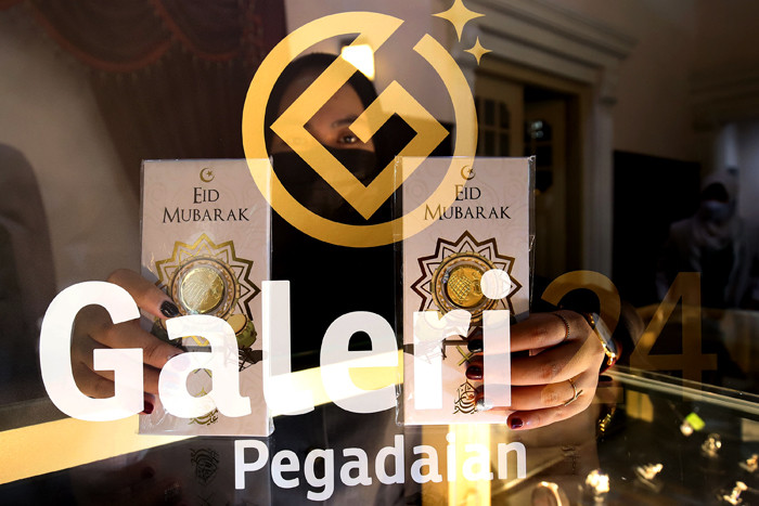 Karyawan menunjukan emas di Galeri 24 Pegadaian, Jakarta, Senin (3/5/2021).