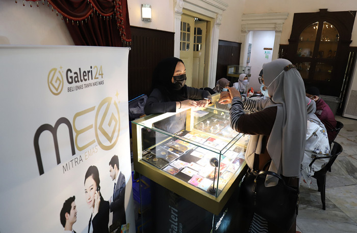 Karyawan menunjukan emas di Galeri 24 Pegadaian, Jakarta, Senin (3/5/2021).