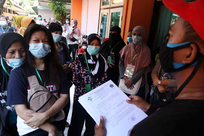 Pekerja Migran Indonesia yang dinyatakan negatif Covid-19 bersiap meninggalkan tempat karantina di Asrama Haji Sukolilo Surabaya, Jawa Timur, Rabu (5/5/2021).