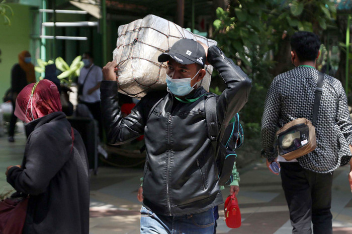 Pekerja Migran Indonesia yang dinyatakan negatif Covid-19 bersiap meninggalkan tempat karantina di Asrama Haji Sukolilo Surabaya, Jawa Timur, Rabu (5/5/2021).