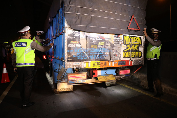 Petugas Kepolisian melakukan pemeriksaan saat penyekatan kendaraan di tol Cikampek KM. 31, Cikarang Barat, Kabupaten Bekasi, Jawa Barat, Kamis (6/5/2021).