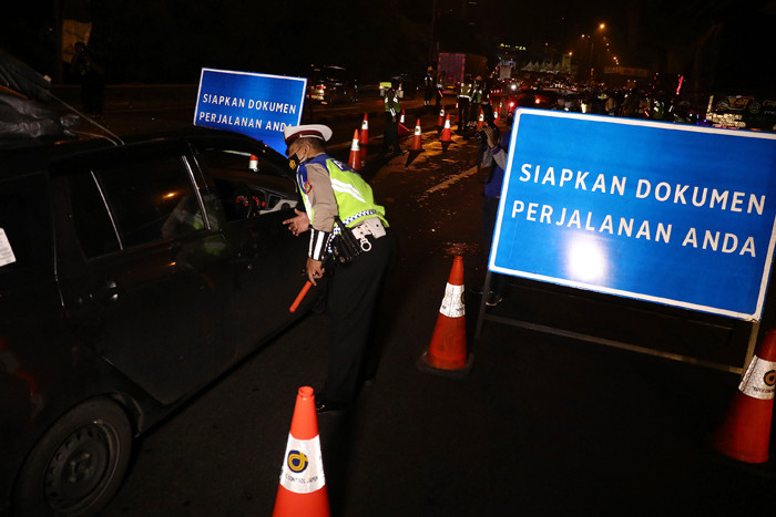 Petugas Kepolisian melakukan pemeriksaan saat penyekatan kendaraan di tol Cikampek KM. 31, Cikarang Barat, Kabupaten Bekasi, Jawa Barat, Kamis (6/5/2021).