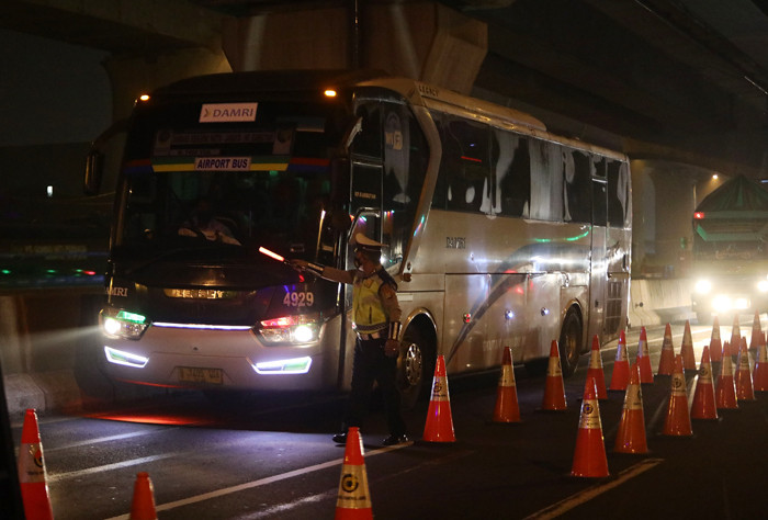 Petugas Kepolisian melakukan pemeriksaan saat penyekatan kendaraan di tol Cikampek KM. 31, Cikarang Barat, Kabupaten Bekasi, Jawa Barat, Kamis (6/5/2021).