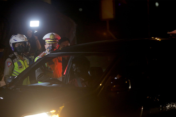 Petugas Kepolisian melakukan pemeriksaan saat penyekatan kendaraan di tol Cikampek KM. 31, Cikarang Barat, Kabupaten Bekasi, Jawa Barat, Kamis (6/5/2021).