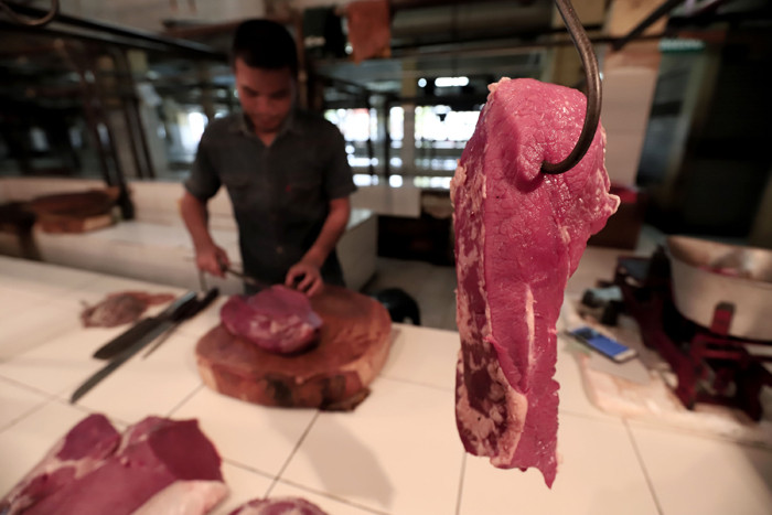 Pedagang memotong daging di Pasar Kramat Jati, Jakarta Timur, Jumat (7/5/2021).