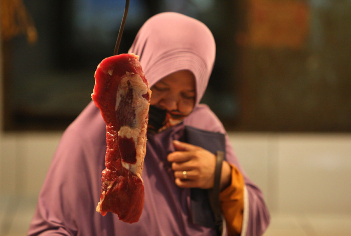 Pedagang memotong daging di Pasar Kramat Jati, Jakarta Timur, Jumat (7/5/2021).