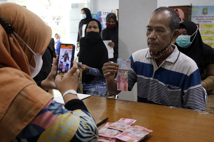 Warga antri untuk mendapatkan Bantuan Sosial Tunai (BST) di Kantor Kelurahan Kreo, Kelurahan Larangan, Kota Tangerang, Banten, Sabtu (8/5/2021).