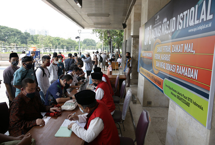Umat Islam membayar zakat fitrah melalui amil zakat di Masjid Istiqlal, Jakarta, Sabtu (8/5/2021).