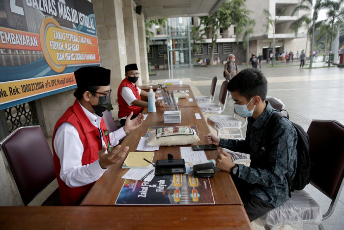 Umat Islam membayar zakat fitrah melalui amil zakat di Masjid Istiqlal, Jakarta, Sabtu (8/5/2021).
