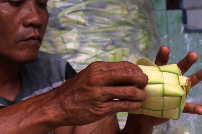 Pengrajin membuat ketupat lebaran di kawasan Pasar Kemayoran, Jakarta Pusat, Senin (10/5/2021).