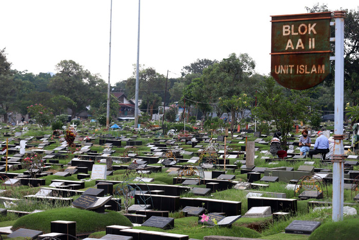 Pekerja makam tidur diatas makam di TPU Tanah Kusir, Jakarta, Selasa (11/5/2021).