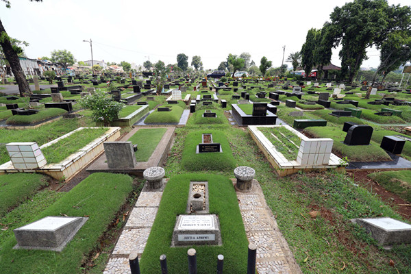 Pekerja makam tidur diatas makam di TPU Tanah Kusir, Jakarta, Selasa (11/5/2021).