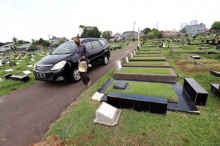 Pekerja makam tidur diatas makam di TPU Tanah Kusir, Jakarta, Selasa (11/5/2021).