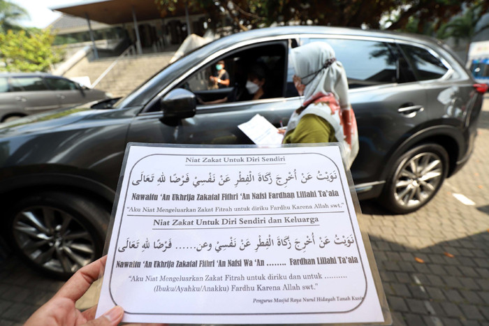 Warga menunaikan zakat fitrah di Gerai Zakat Infak dan Shodaqoh Drive Thru di Masjid Raya Nurul Hidayah, Tanah Kusir, Jakarta Selatan, Selasa (11/5/2021).