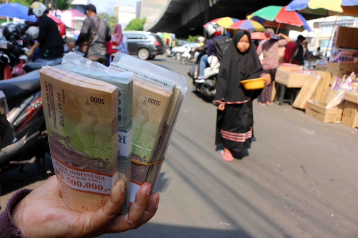 Penjual jasa penukaran uang menawarkan uang baru yang banyak dibutuhkan selama Lebaran di kawasan Pasar Asemka, Jakarta, Rabu (12/5/2021).