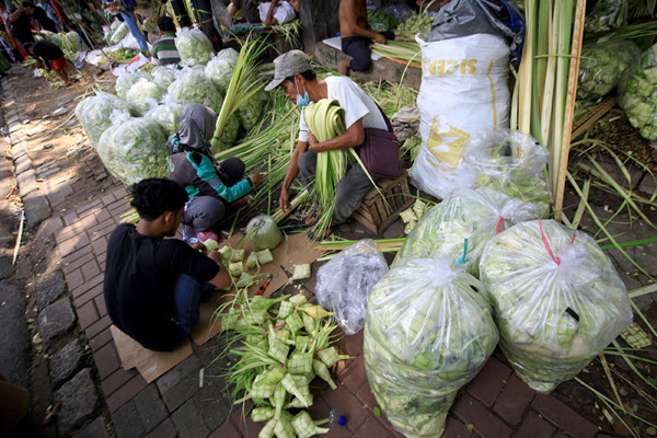 Pedagang menyelesaikan pembuatan kulit ketupat yang dijual di kawasan Palmerah, Jakarta, Rabu (12/5/2021).