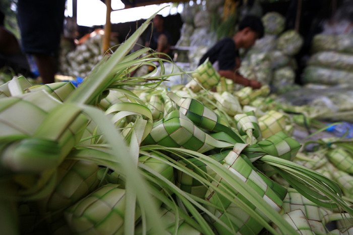 Pedagang menyelesaikan pembuatan kulit ketupat yang dijual di kawasan Palmerah, Jakarta, Rabu (12/5/2021).