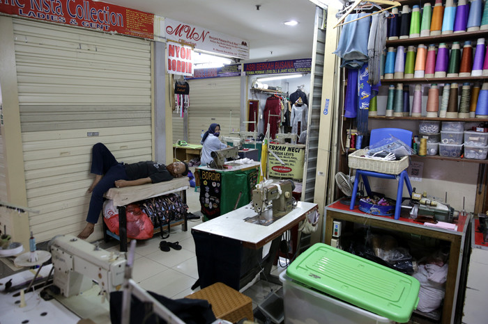 Penjahit mengerjakan pesanan jahitannya di Pasar Mayestik, Jakarta Selatan, Selasa (11/5/2021).