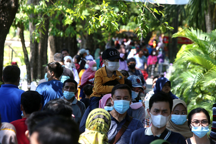 Pengunjung merasakan sensasi memberikan makan satwa ketika berwisata di Kebun Binatang Surabaya (KBS), Jawa Timur, Jumat (14/5/2021).
