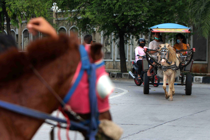 Warga memanfaat waktu liburan bersama keluarga berkeliling menunggang kuda di kawasan Kemayoran, Jakarta Pusat, Jumat (14/5/2021).