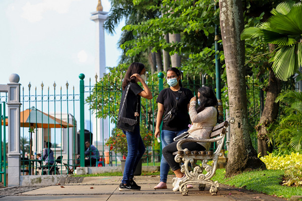 Warga di luar pagar Monumen Nasional (Monas) yang tutup di Jakarta Pusat, Sabtu (15/5/2021).