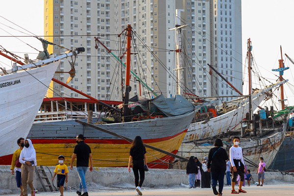 Warga menikmati pemandangan Pelabuhan Sunda Kelapa, Jakarta Utara, Sabtu (15/5/2021).