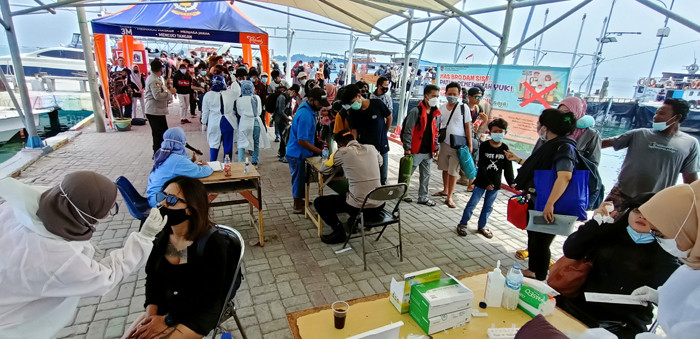 Petugas gabungan kesehatan dan kepolisian memeriksa kesehatan tamu dan wisatawan yang datang ke Pulau Pramuka, Kepulauan Seribu, Jakarta, Sabtu (15/5/2021).