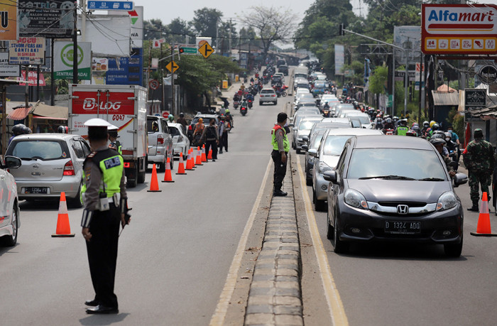 Petugas melakukan penyekatan kendaraan di Kawasan Jalan Raya Parung-Ciputat, Bojong Sari, Depok, Jawa Barat, Minggu (16/5/2021).