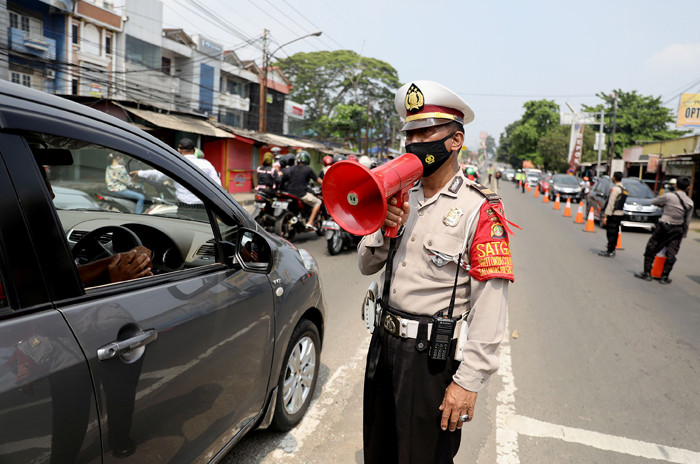Petugas melakukan penyekatan kendaraan di Kawasan Jalan Raya Parung-Ciputat, Bojong Sari, Depok, Jawa Barat, Minggu (16/5/2021).
